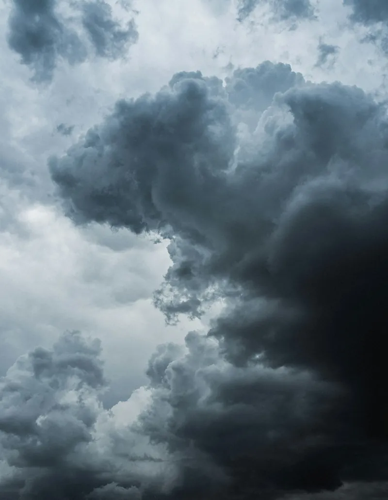 Cielo cubierto de protuberancias globulares doradas y azuladas colgando de la base de una gran nube de tormenta.